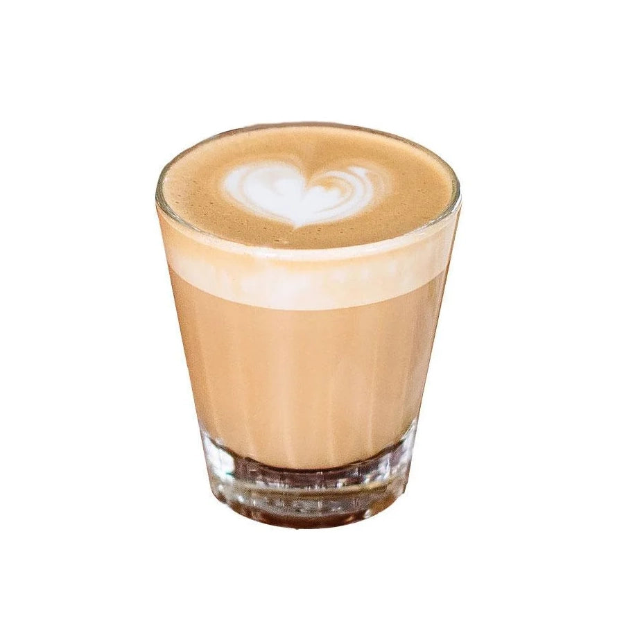 latte with heart foam art in coffee glass