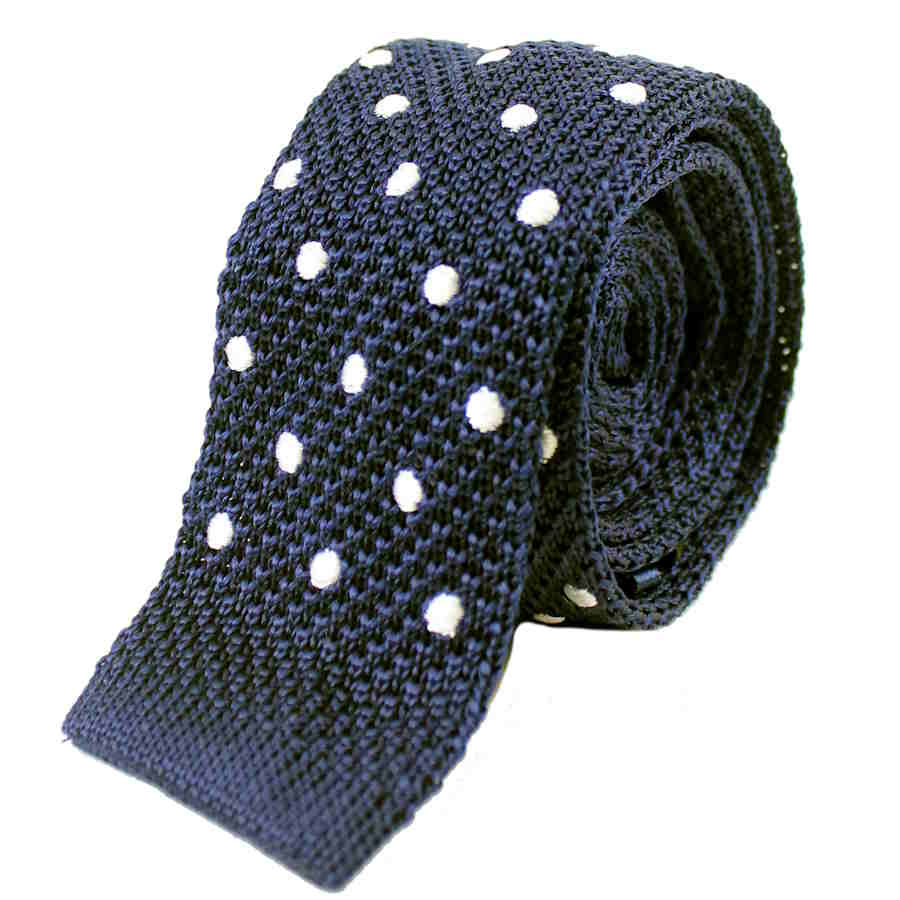 navy blue with white polka dot knitted silk tie rolled up with the straight edge end showing